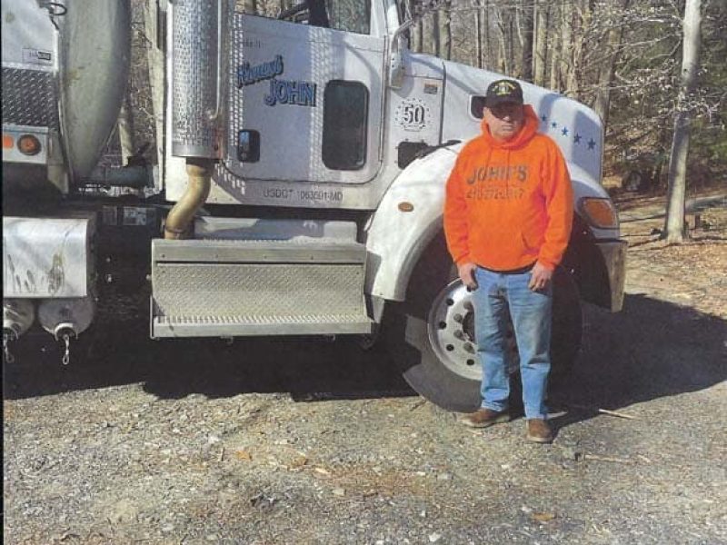 John of John’s Septic Service standing beside company truck in Maryland