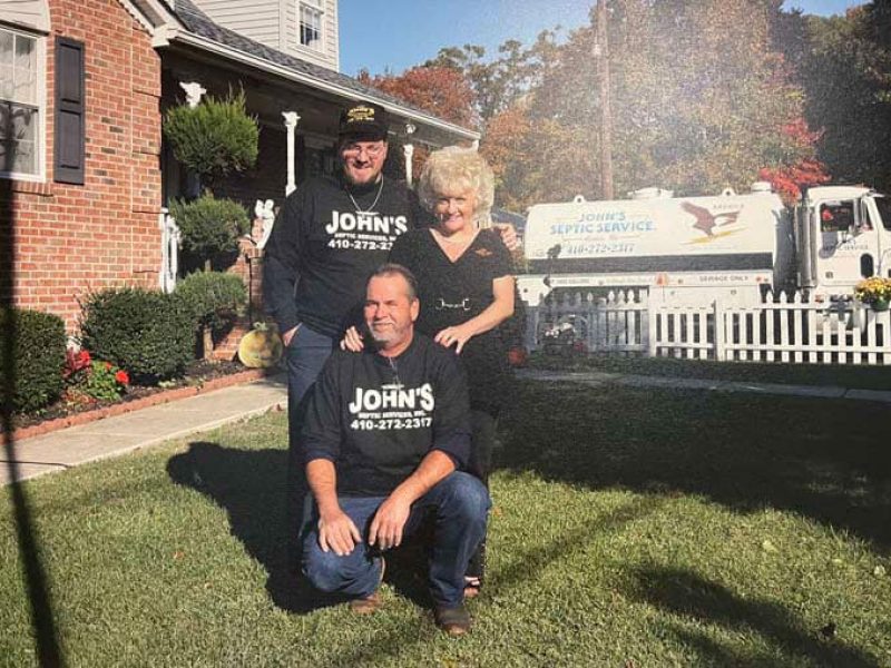 John’s Septic Service family team standing with company truck in Maryland