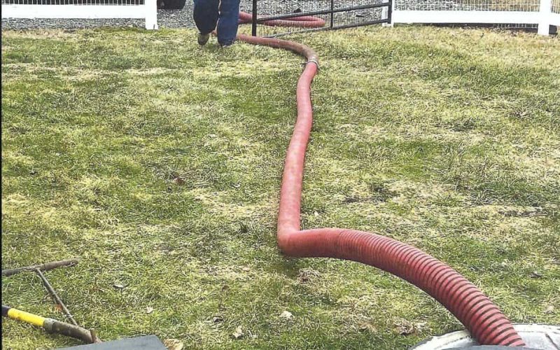 Septic repair technician working at a septic tank access point in Cecil County, Maryland
